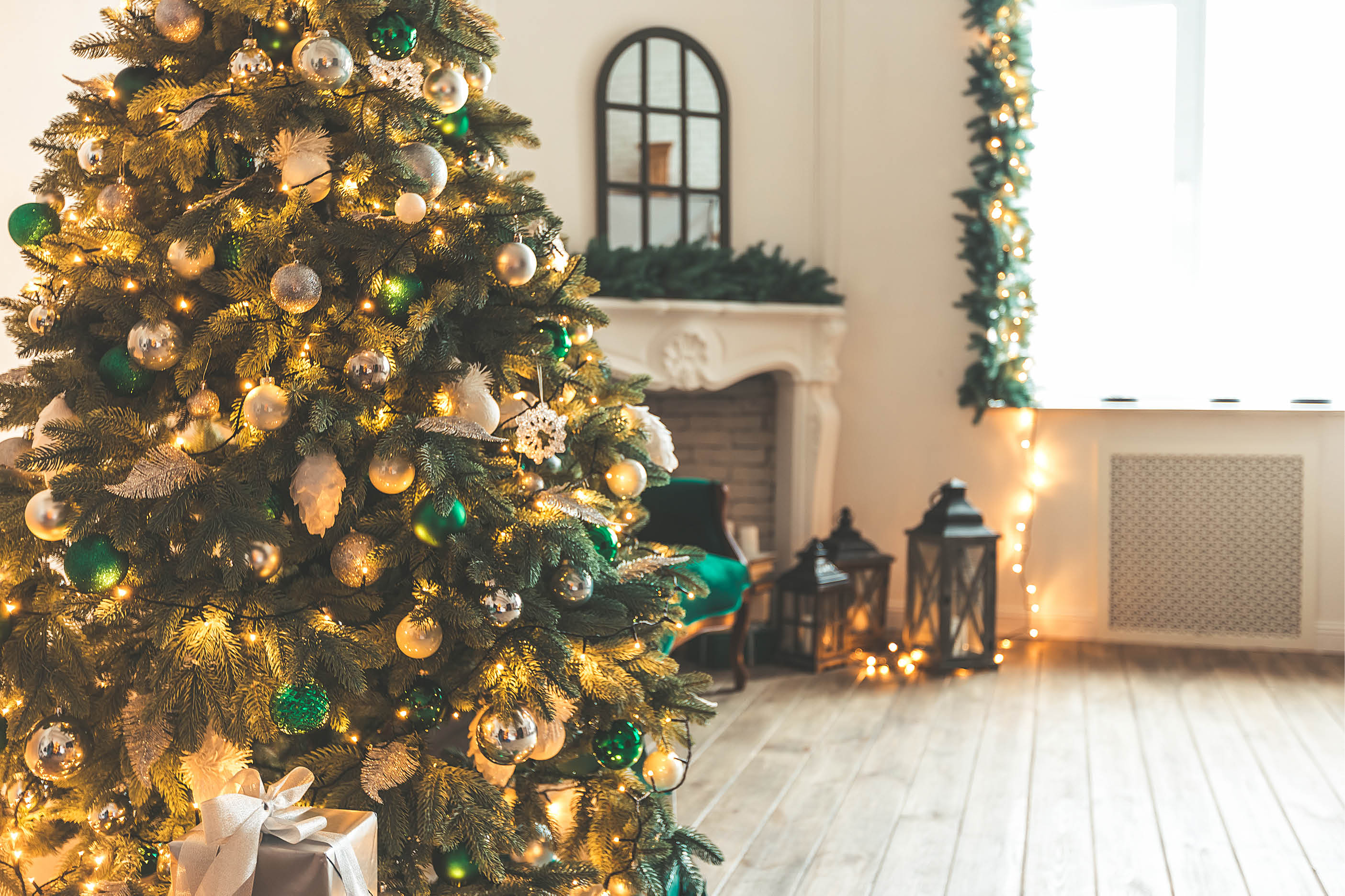 Christmas living room with a fireplace, sofa, Christmas tree and gifts. Beautiful New Year decorated classic home interior. Winter background
