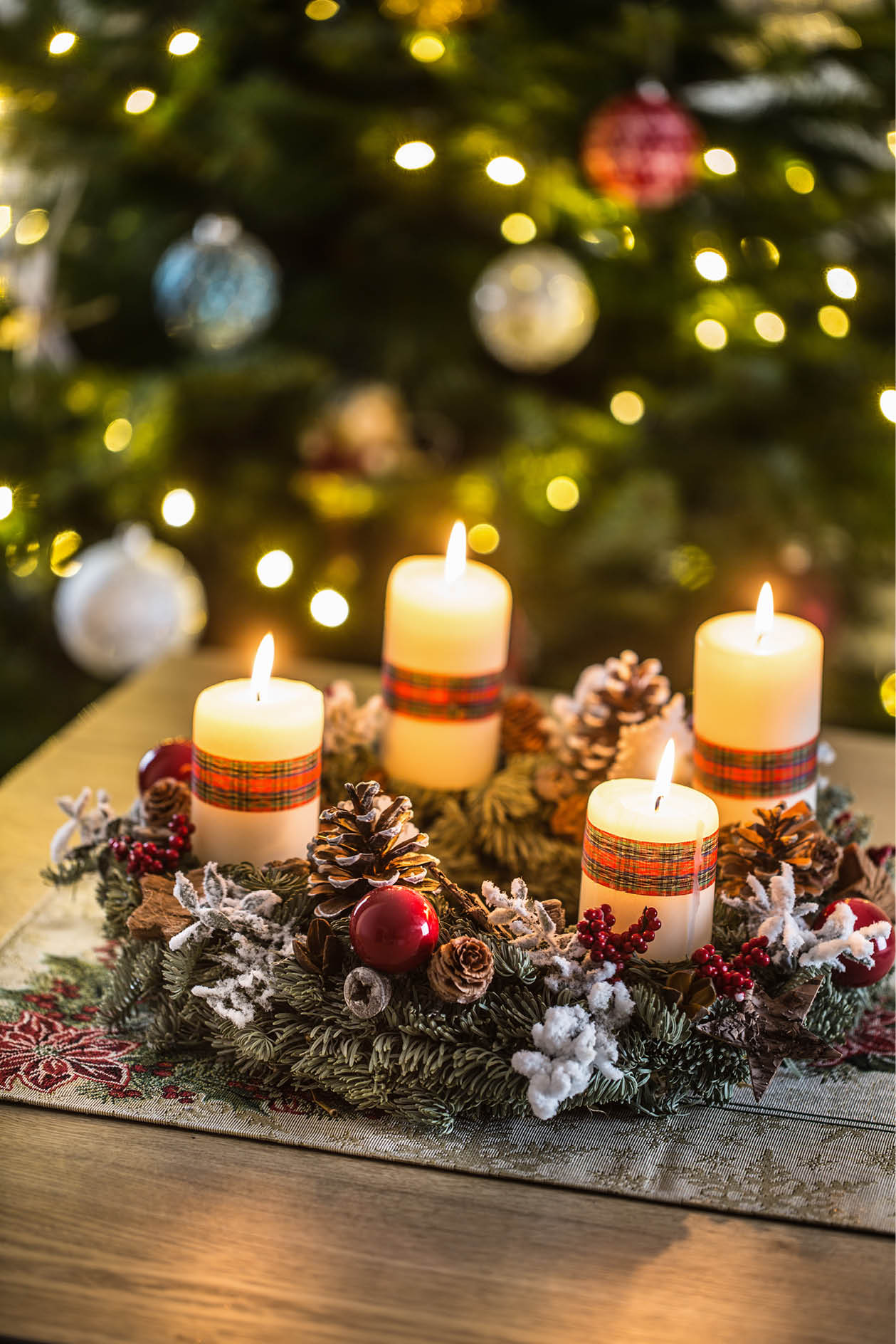 Advent wreath with four white burning candles christmas ball and decorations on a wooden background with festive atmosphere.