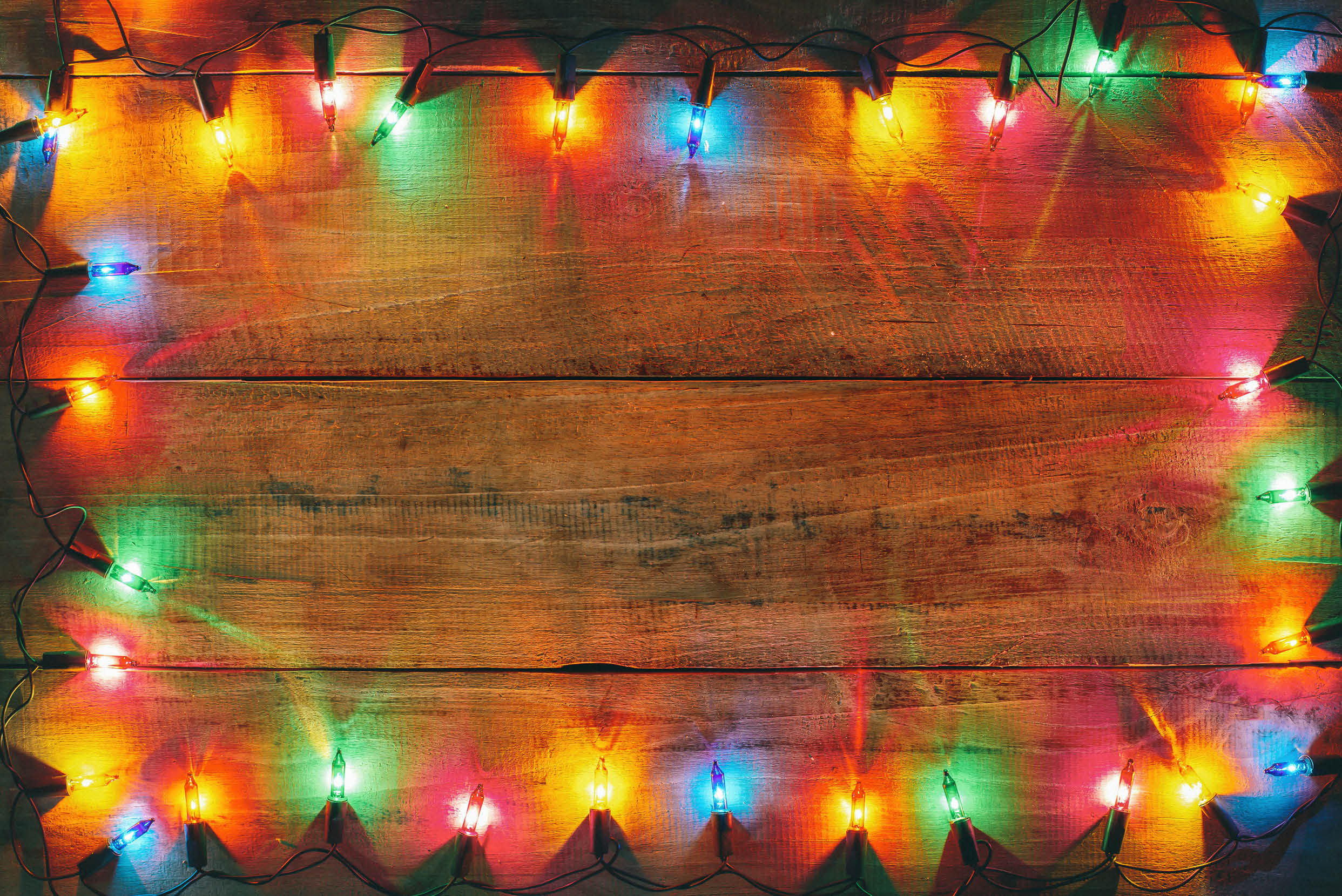 Vintage Christmas lights bulb decoration on old wood plank. Merry Christmas and New Year holiday background. vintage color tone.
