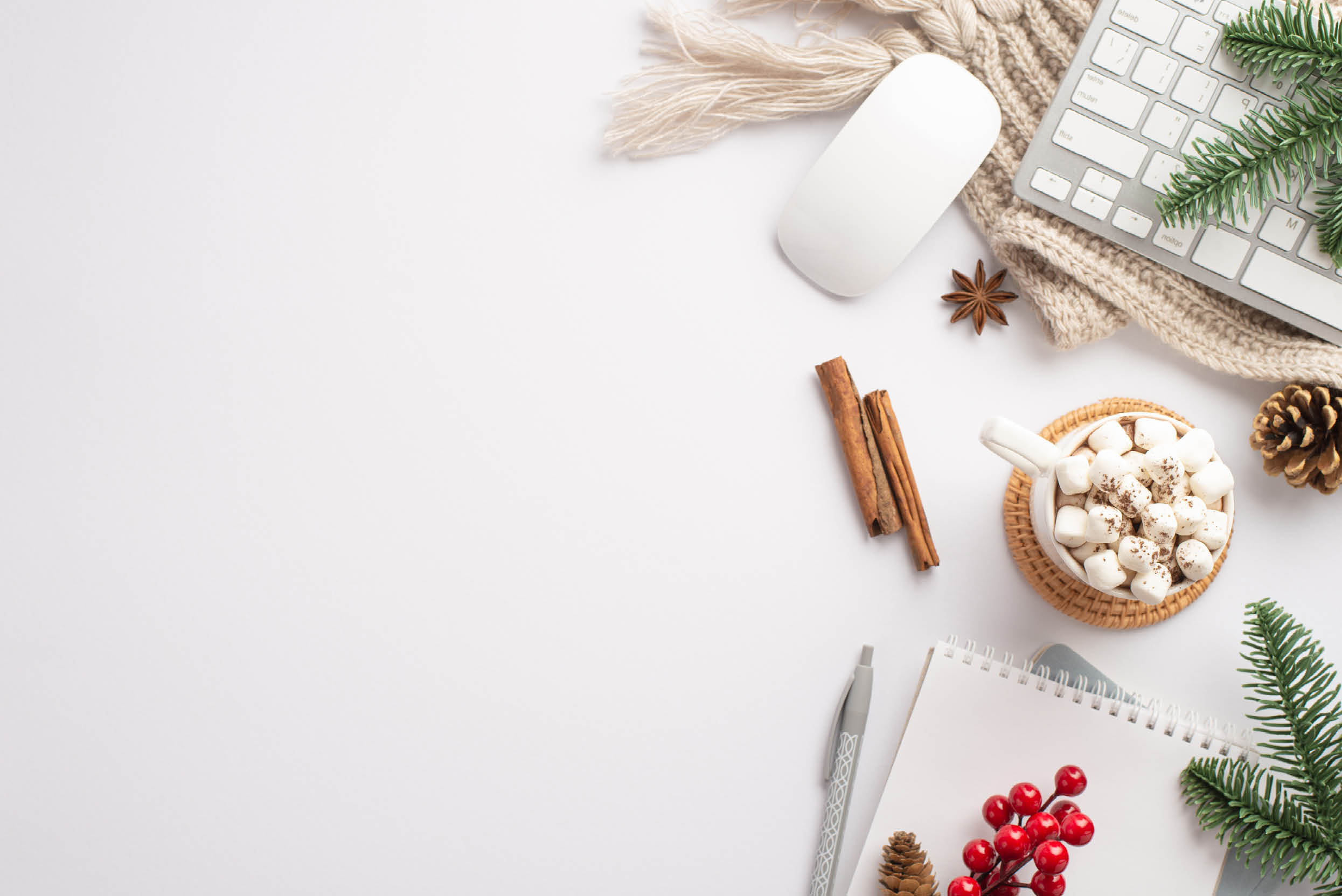 Winter concept. Top view photo of keyboard computer mouse cup of cocoa with marshmallow diaries pen pine cone branches mistletoe cinnamon sticks anise and knitted plaid on isolated white background