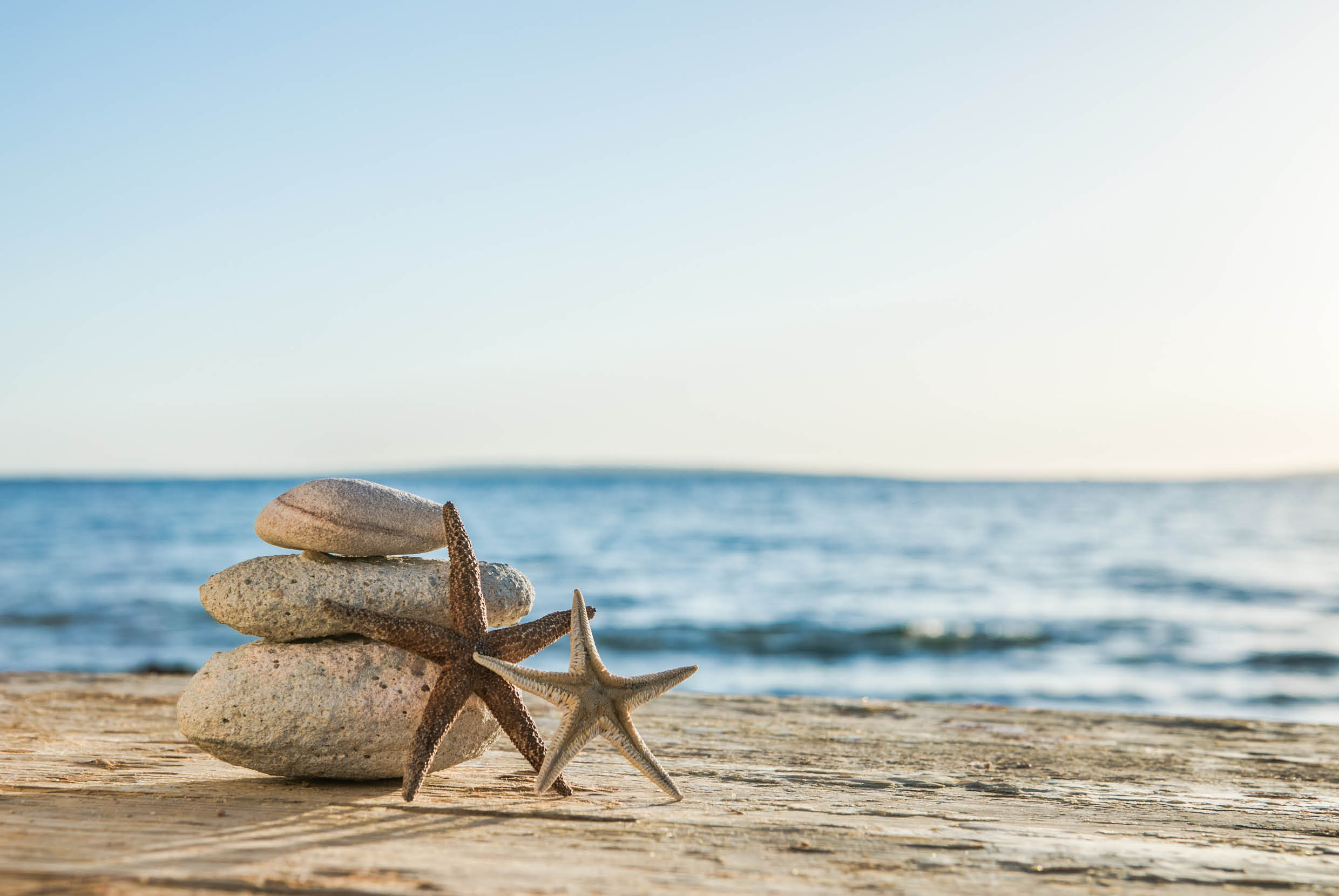 Blue Sea on Background Selective focus, zen stones on sea beach, meditation, spa, harmony, calm, balance concept