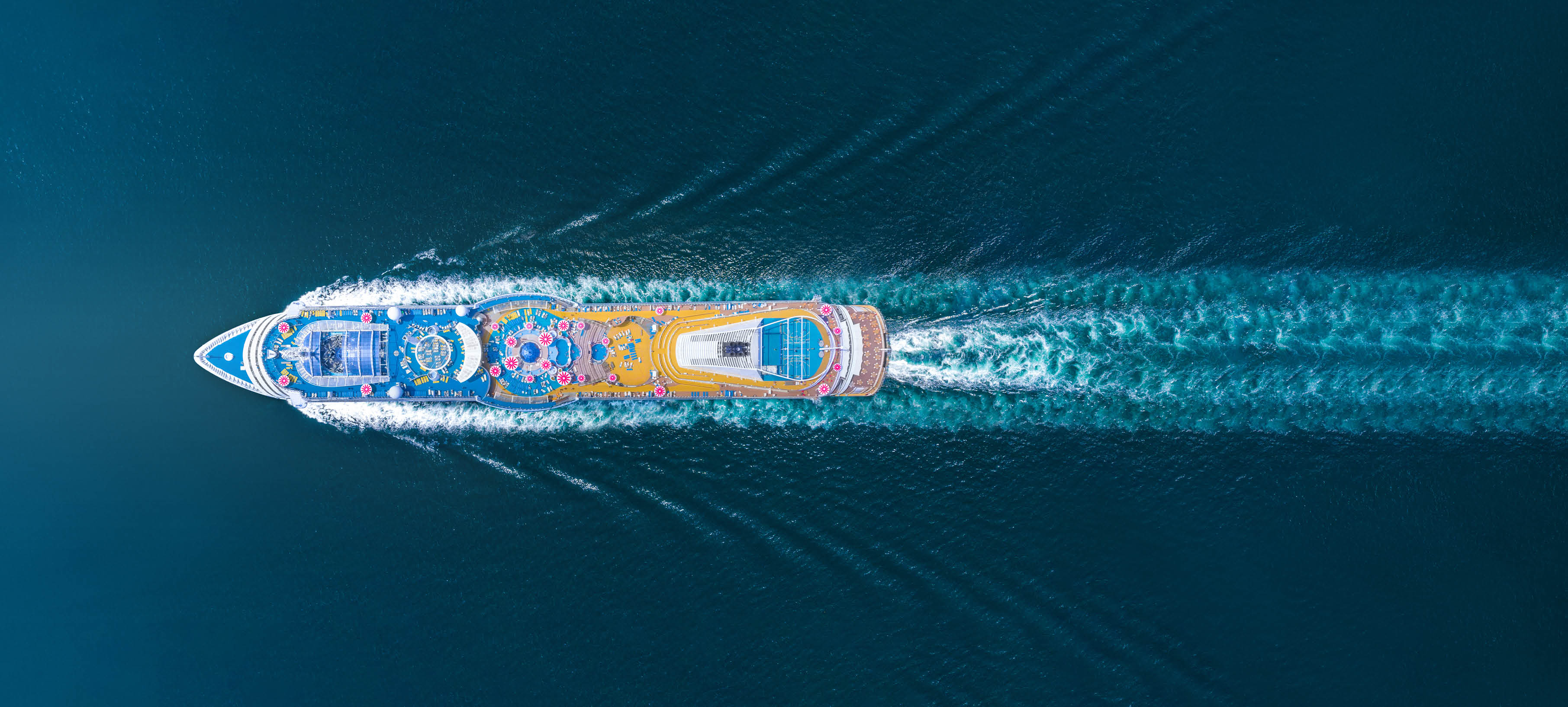 A boat with a yellow and orange top is on the water. Description generated by AI