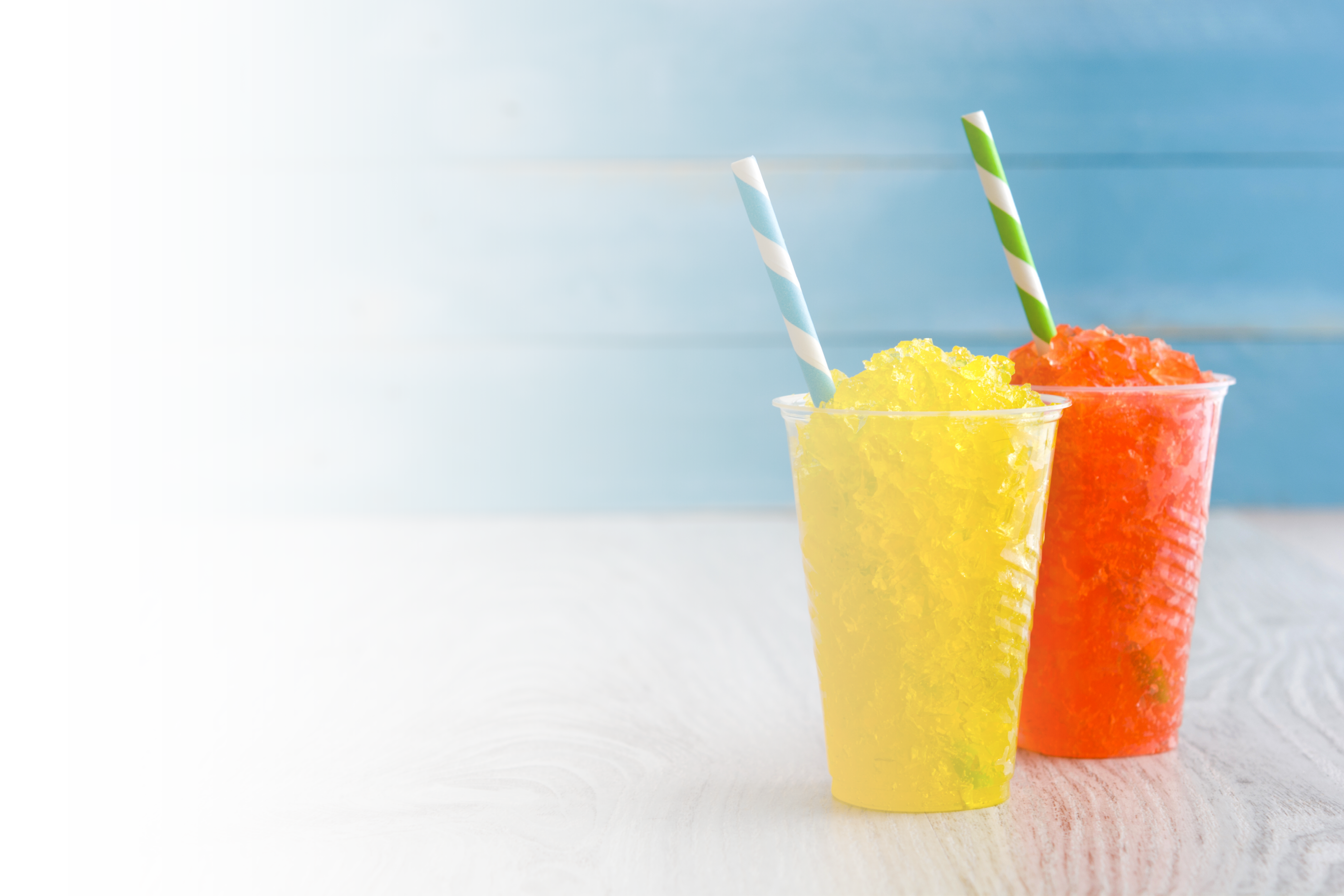 Two plastic cups filled with yellow and orange liquid. Description generated by AI