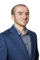 A man wearing a gray suit and striped shirt. Description generated by AI